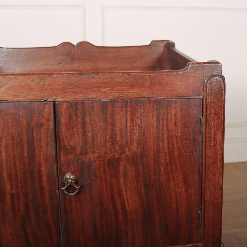 A Georgian mahogany tray-top bedside table featuring a double-door cupboard above a single drawer with a brass drop handle, supported by straight square legs. View V