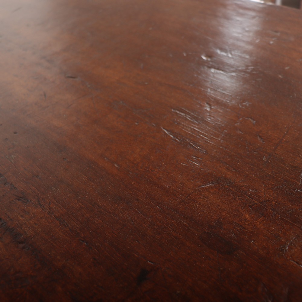 An antique dark walnut trestle table featuring turned baluster legs, carved scroll feet, and a turned central stretcher. View VIII