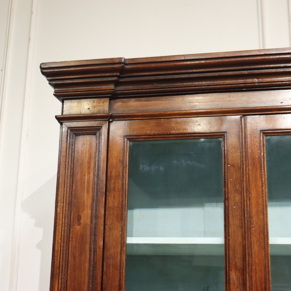 A large Italian dark walnut bookcase featuring four upper glass doors, four small drawers, and four fielded panel doors below. View II