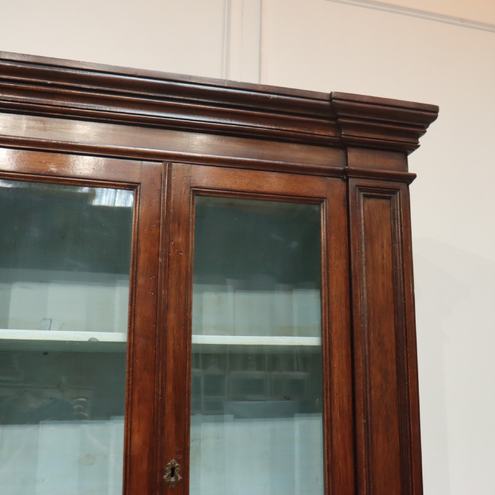 A large Italian dark walnut bookcase featuring four upper glass doors, four small drawers, and four fielded panel doors below. View III