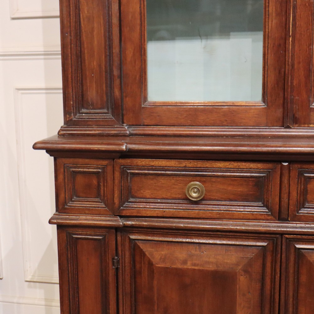 A large Italian dark walnut bookcase featuring four upper glass doors, four small drawers, and four fielded panel doors below. View V