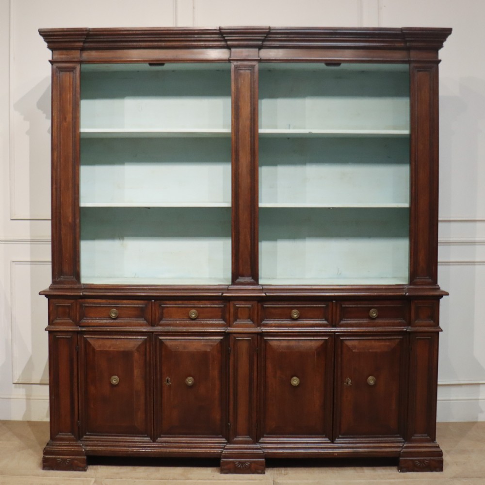 A large Italian dark walnut bookcase featuring four upper glass doors, four small drawers, and four fielded panel doors below. View IX