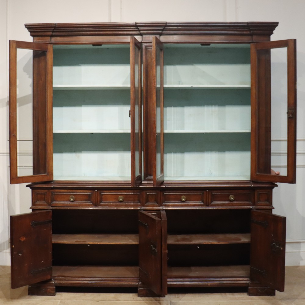 A large Italian dark walnut bookcase featuring four upper glass doors, four small drawers, and four fielded panel doors below. View XI