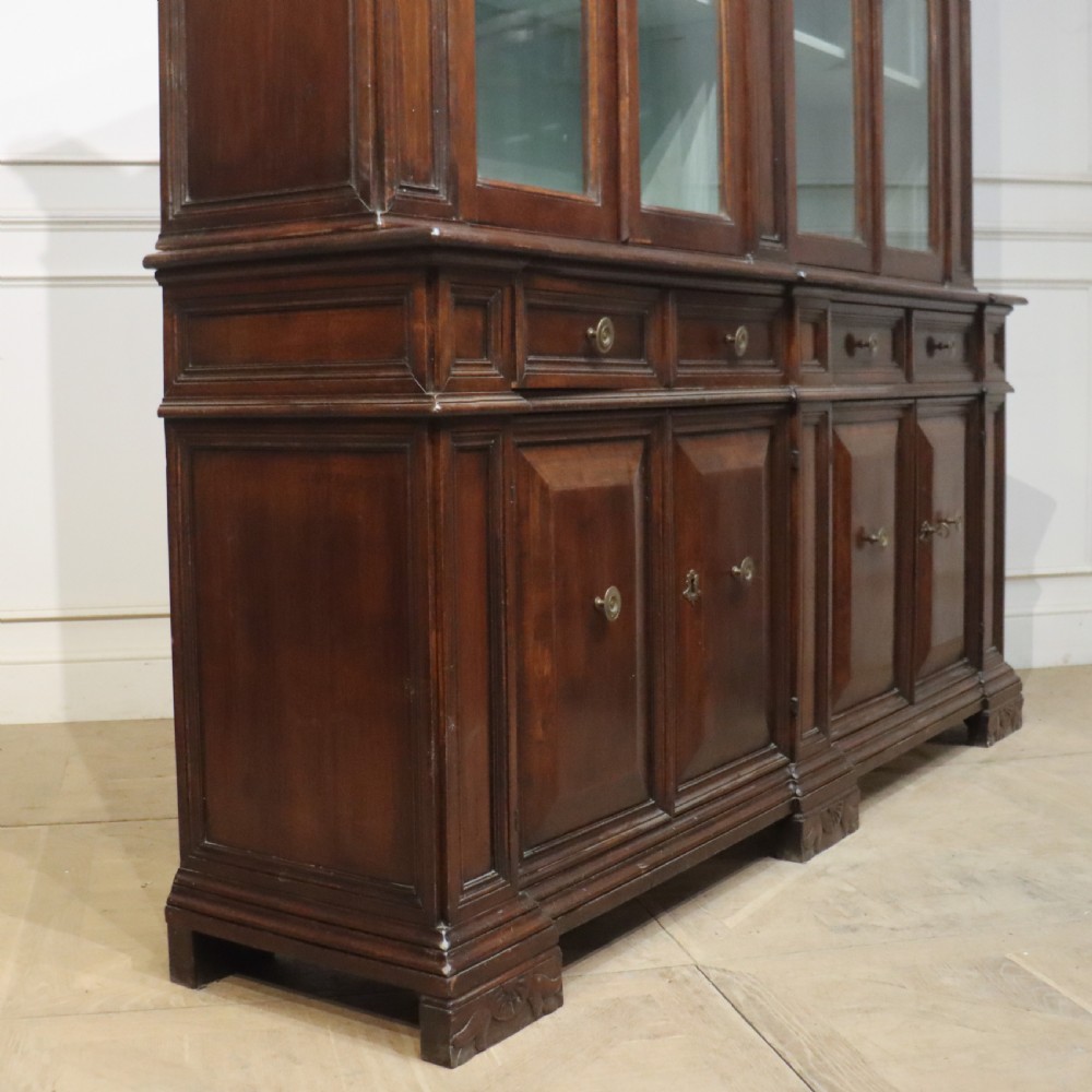 A large Italian dark walnut bookcase featuring four upper glass doors, four small drawers, and four fielded panel doors below. View XIII