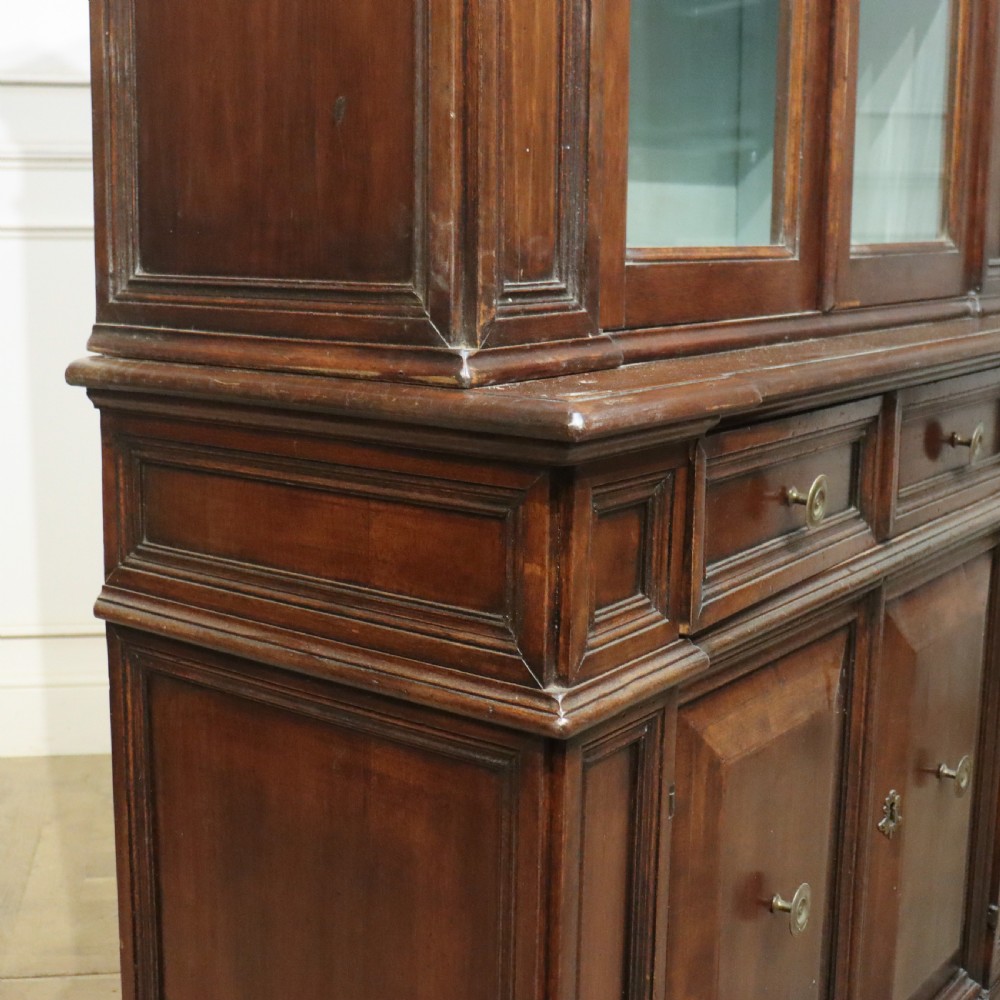 A large Italian dark walnut bookcase featuring four upper glass doors, four small drawers, and four fielded panel doors below. View XIV