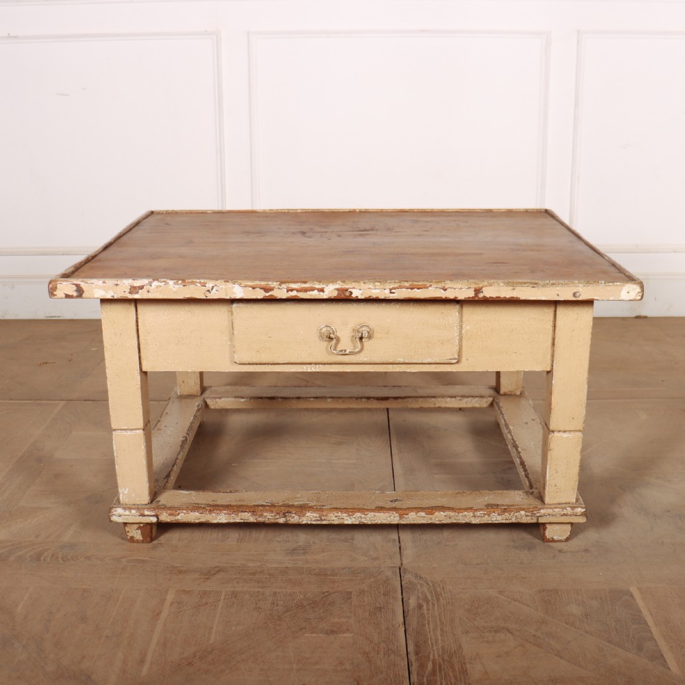 A rectangular low painted coffee table featuring a distressed cream paint finish, a single drawer with a metal drop handle, and a perimeter floor stretcher. View II