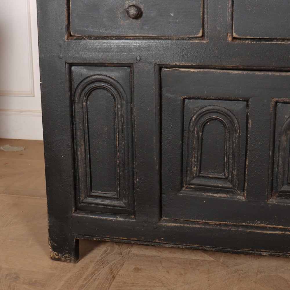An 18th-century dark painted wooden dresser base featuring four frieze drawers above recessed cupboard doors decorated with geometric arch mouldings. View III