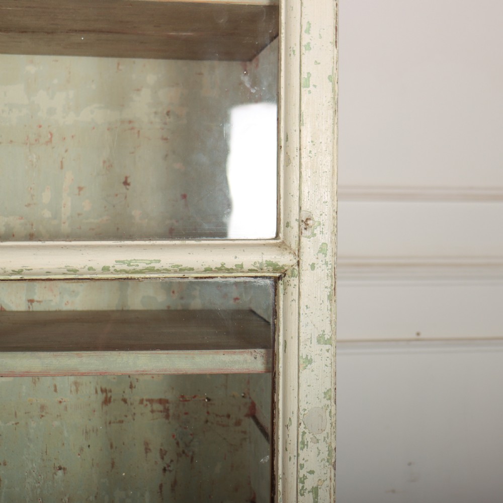 A tall Georgian painted bookcase featuring two multi-pane glazed doors above nine drawers with brass handles. View XI