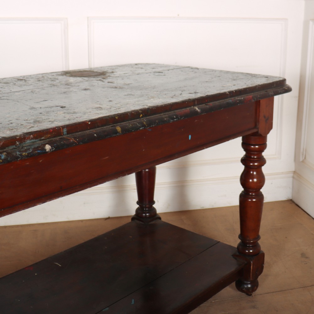 A long Victorian mahogany drapers table featuring turned legs and a low potboard shelf. View III