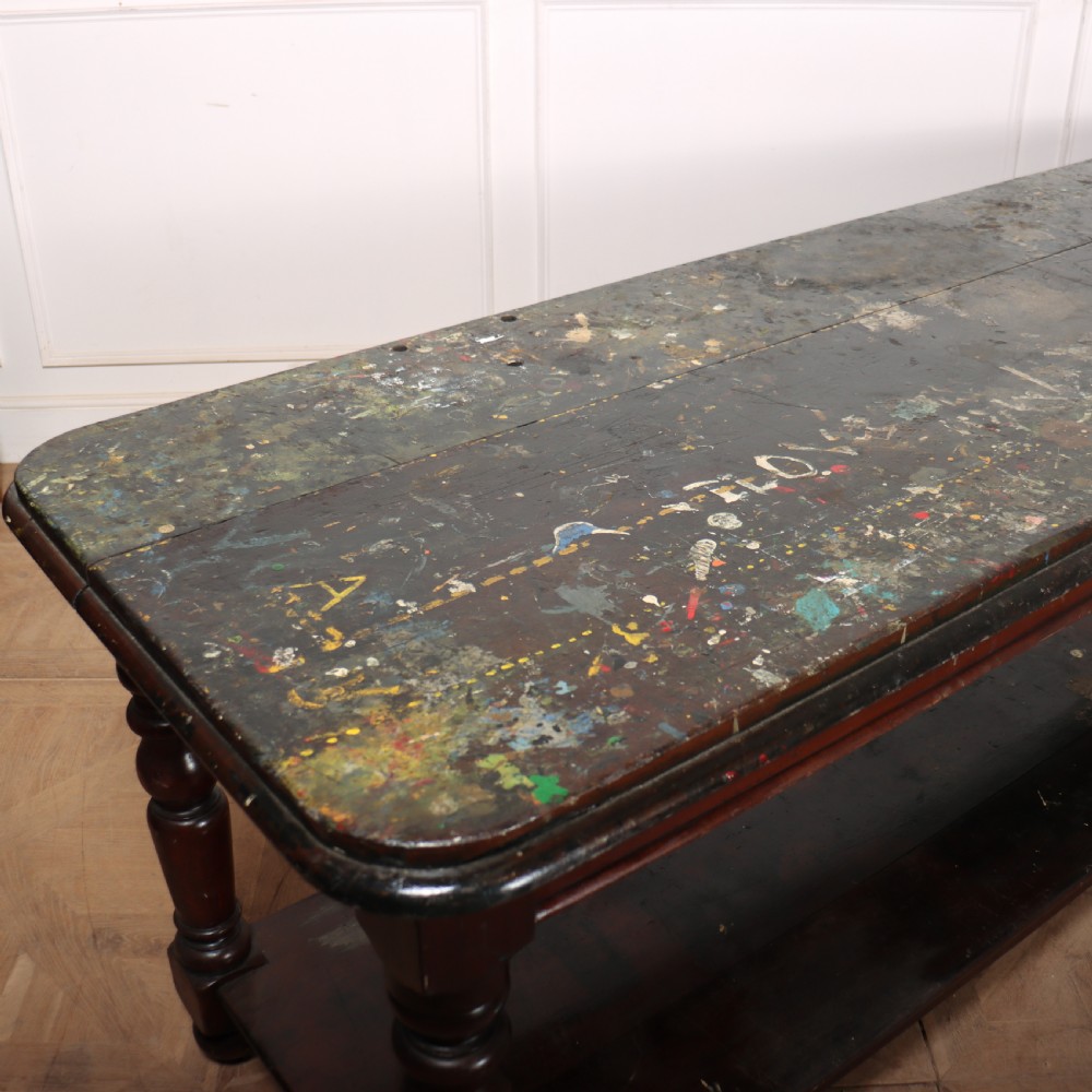 A long Victorian mahogany drapers table featuring turned legs and a low potboard shelf. View IV