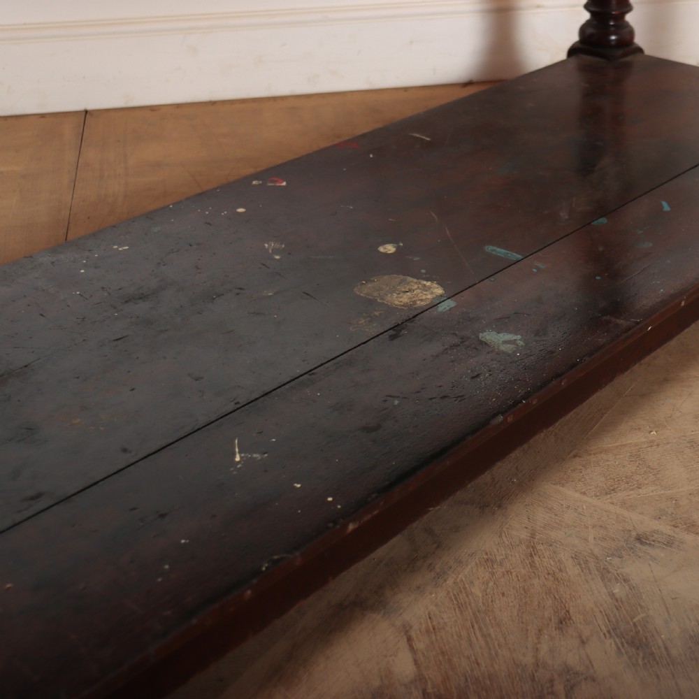 A long Victorian mahogany drapers table featuring turned legs and a low potboard shelf. View X