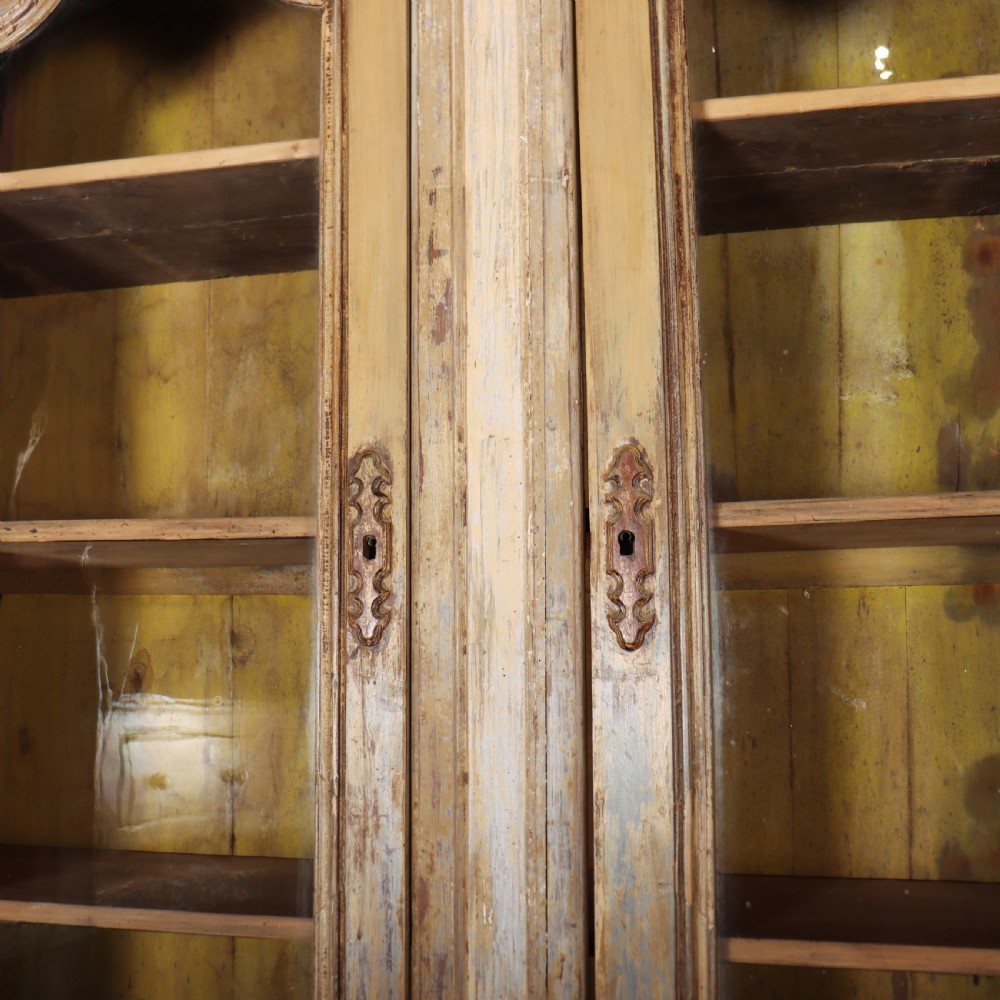 A large antique French library bookcase with four glazed upper doors, four panelled lower doors, and a distressed painted finish. View X