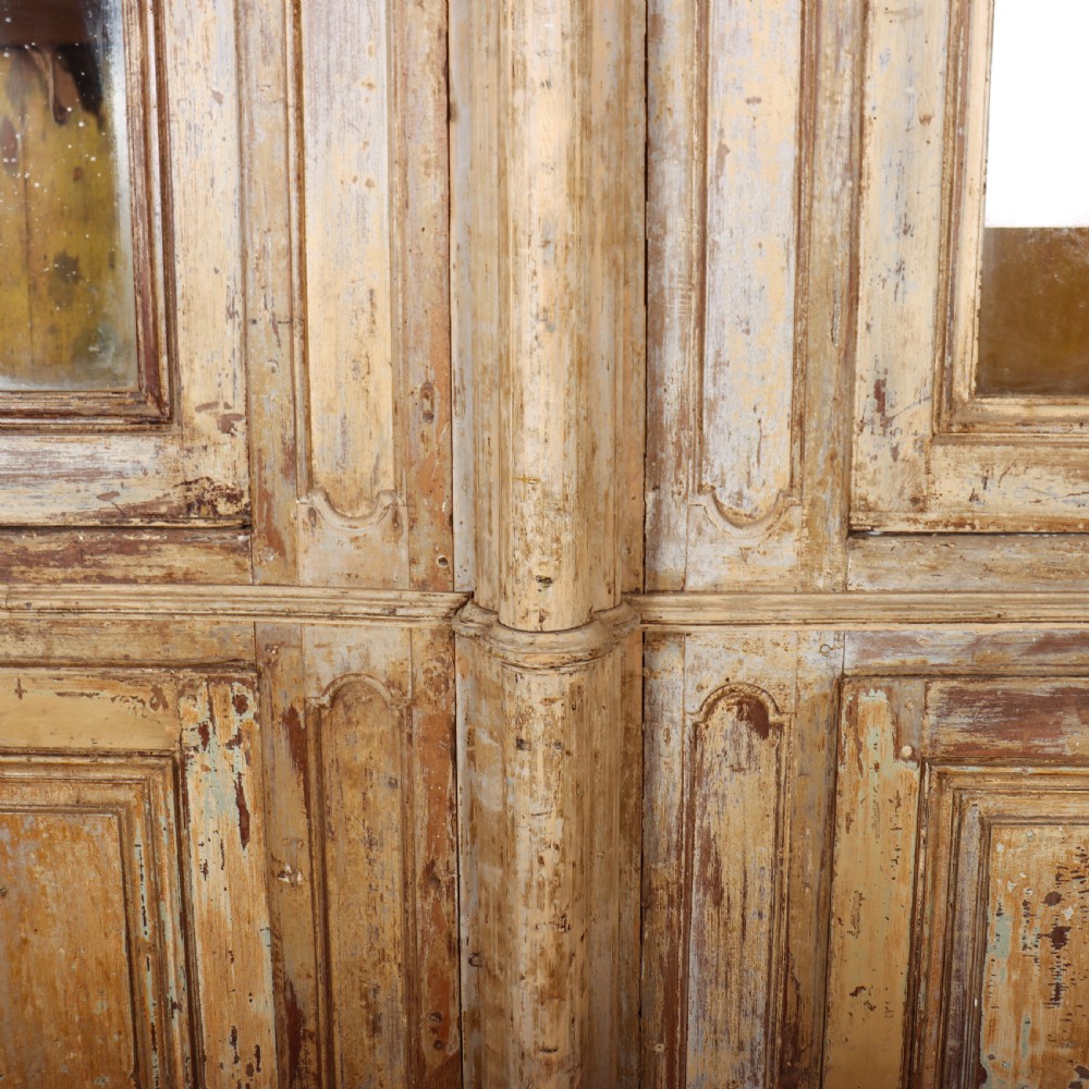 A large antique French library bookcase with four glazed upper doors, four panelled lower doors, and a distressed painted finish. View XII