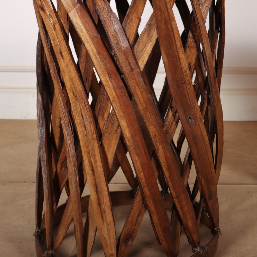 A rustic furniture set featuring a curved tub armchair and a matching round side table, both constructed with diagonally woven willow slat bases and tan leather tops. View IV