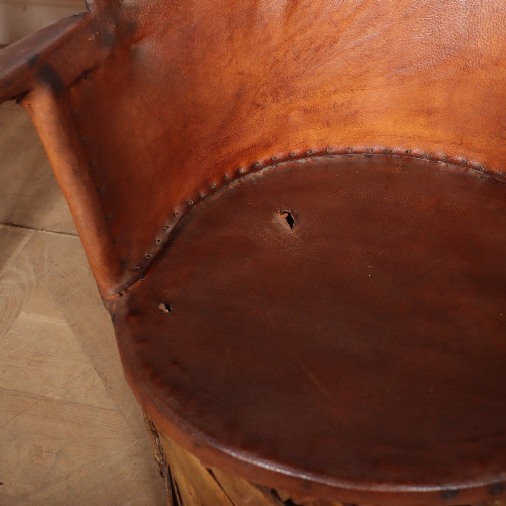 A rustic furniture set featuring a curved tub armchair and a matching round side table, both constructed with diagonally woven willow slat bases and tan leather tops. View VII
