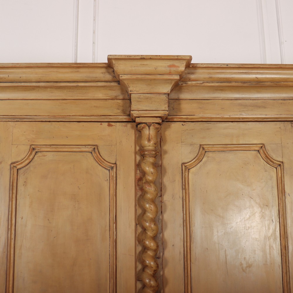 A large four-door cream painted wooden wardrobe featuring carved barley twist pilasters and shaped door panels. View III