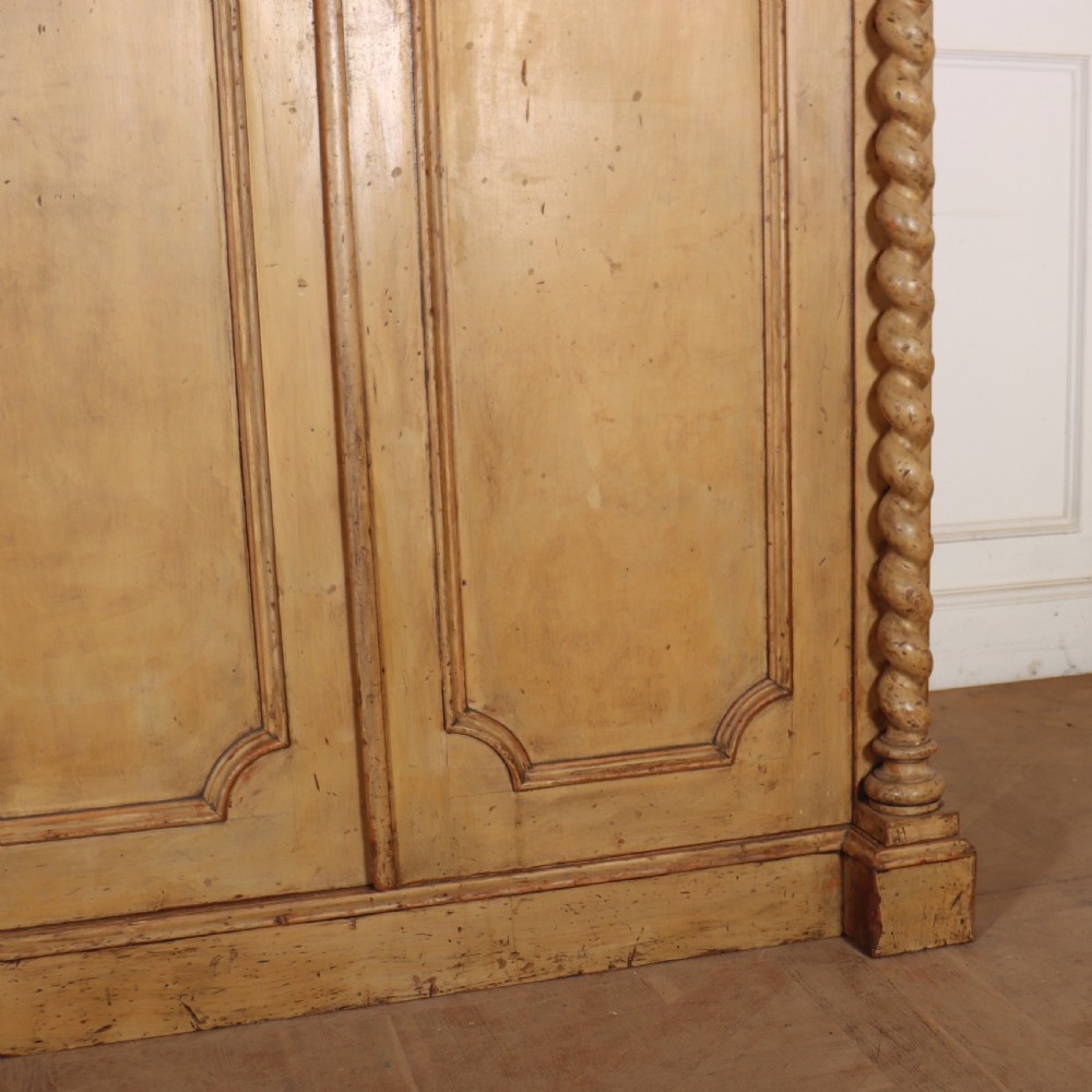 A large four-door cream painted wooden wardrobe featuring carved barley twist pilasters and shaped door panels. View IV