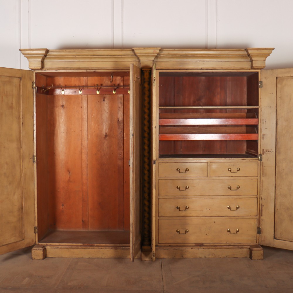 A large four-door cream painted wooden wardrobe featuring carved barley twist pilasters and shaped door panels. View X