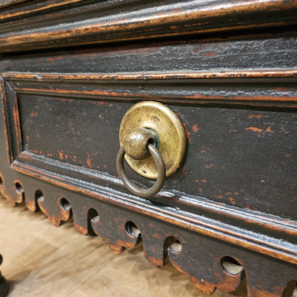 A 19th-century French ebonised timber butchers block featuring a carved splashback with brass bull head mounts, turned legs, and lower drawers. View VII