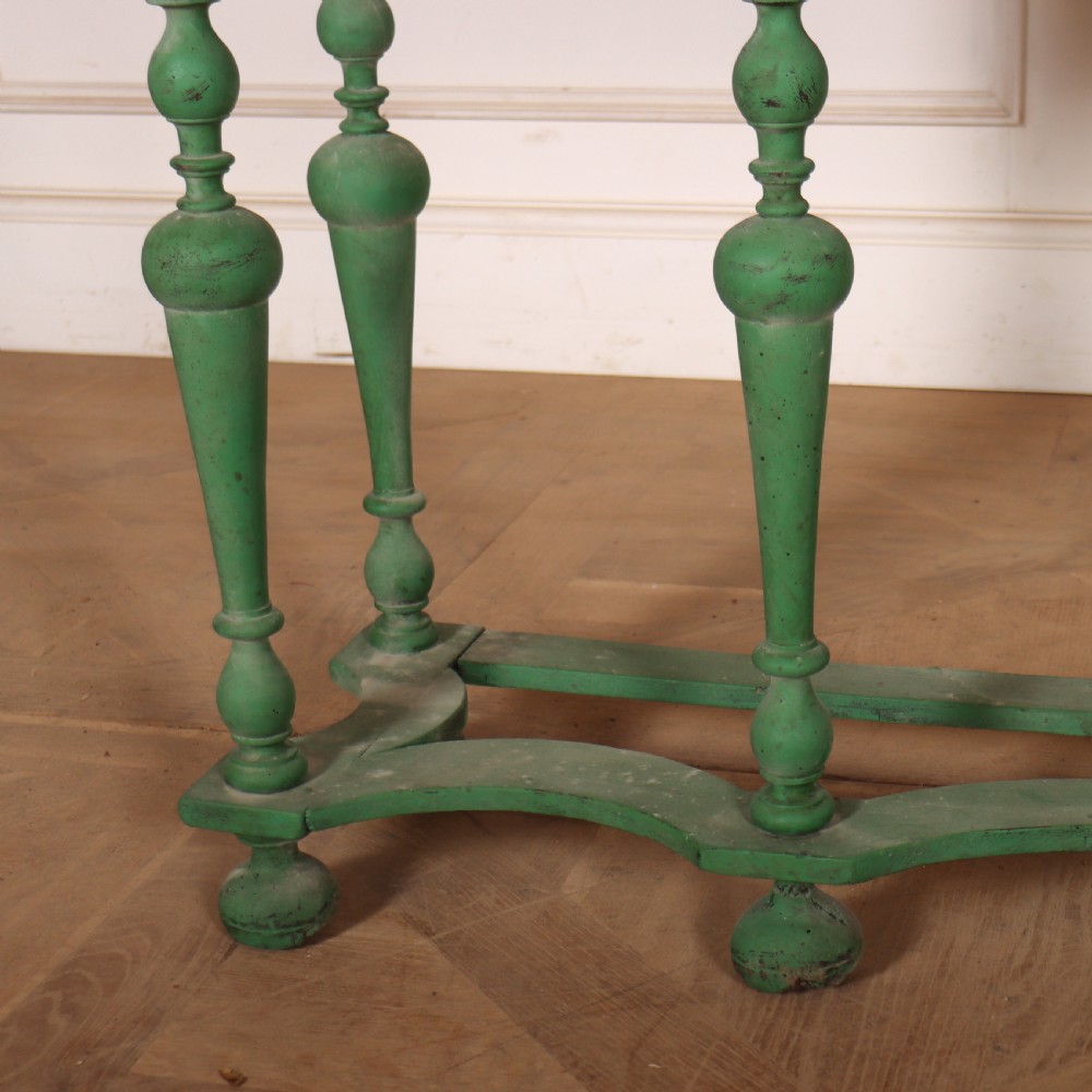 A 19th-century green painted display cabinet featuring twin arched glazed doors, a scalloped apron, and six turned legs joined by a shaped stretcher. View VII