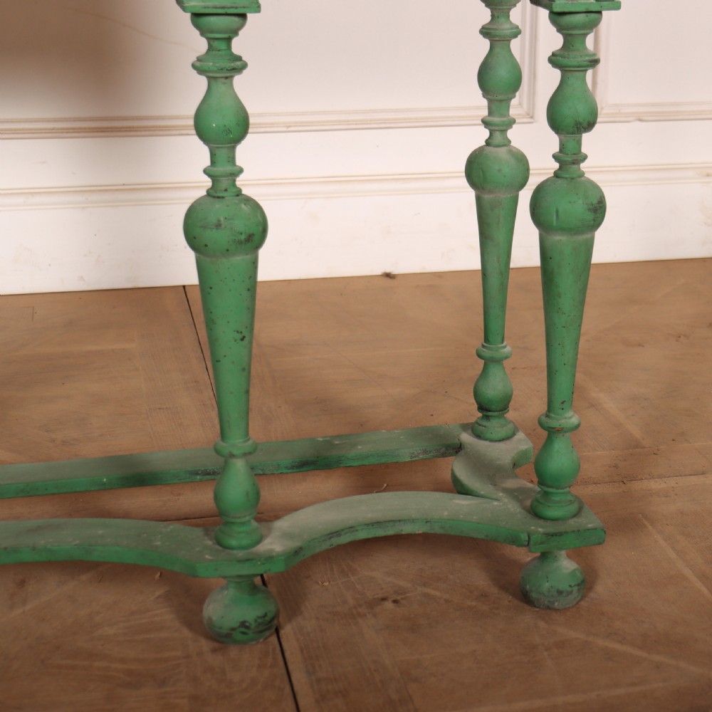 A 19th-century green painted display cabinet featuring twin arched glazed doors, a scalloped apron, and six turned legs joined by a shaped stretcher. View VIII