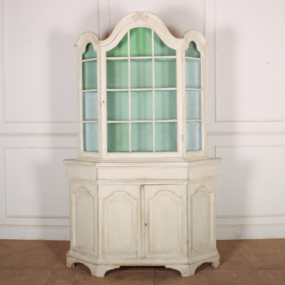 An 18th-century Dutch painted vitrine cabinet featuring an arched glass upper display section with green shelves over a double-door lower storage cupboard.