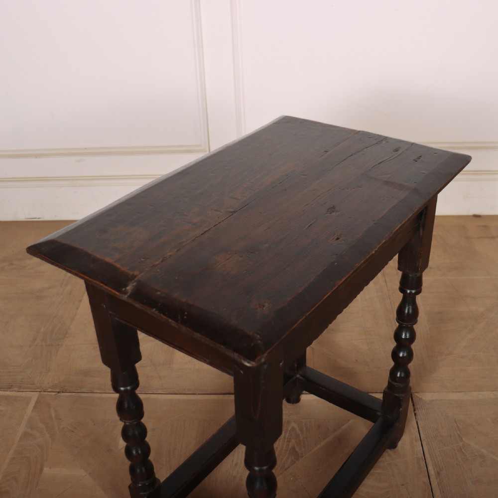 An 18th-century dark oak side table featuring turned legs, lower box stretchers, and a carved apron frieze. View VIII