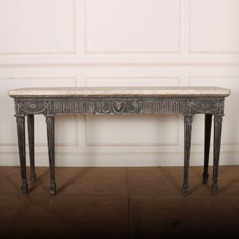 A Neoclassical dark grey painted console table with a marble top, featuring carved garland festoons and fluted tapered legs.