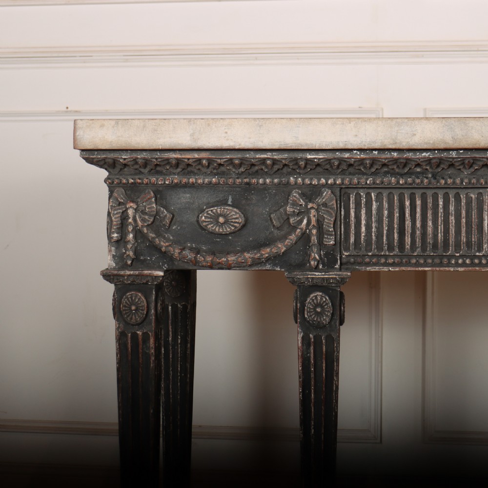 A Neoclassical dark grey painted console table with a marble top, featuring carved garland festoons and fluted tapered legs. View II