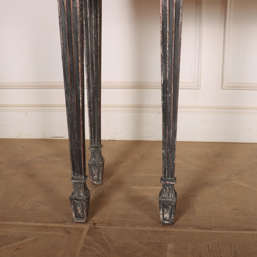 A Neoclassical dark grey painted console table with a marble top, featuring carved garland festoons and fluted tapered legs. View III
