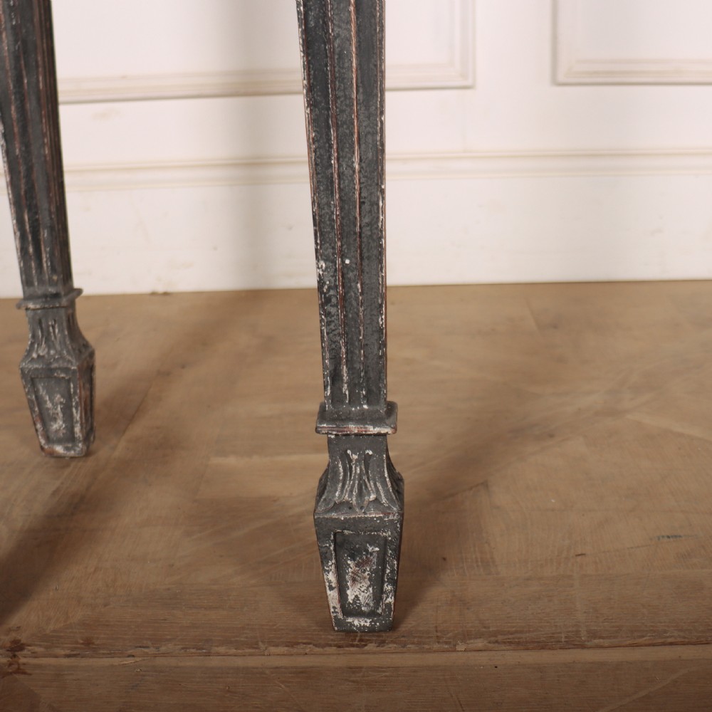 A Neoclassical dark grey painted console table with a marble top, featuring carved garland festoons and fluted tapered legs. View IV