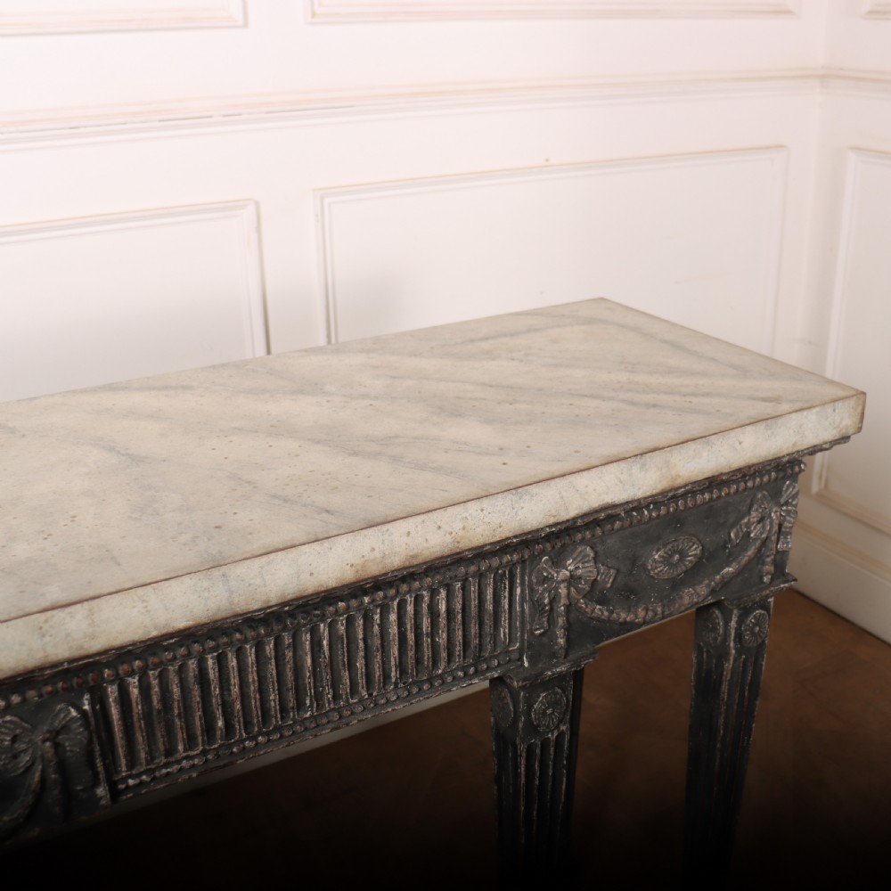 A Neoclassical dark grey painted console table with a marble top, featuring carved garland festoons and fluted tapered legs. View VIII