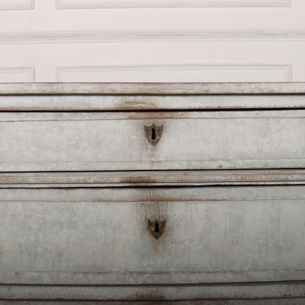 A Louis XVI style pale grey painted oak commode featuring three drawers with gilded rosette handles and fluted legs. View VI