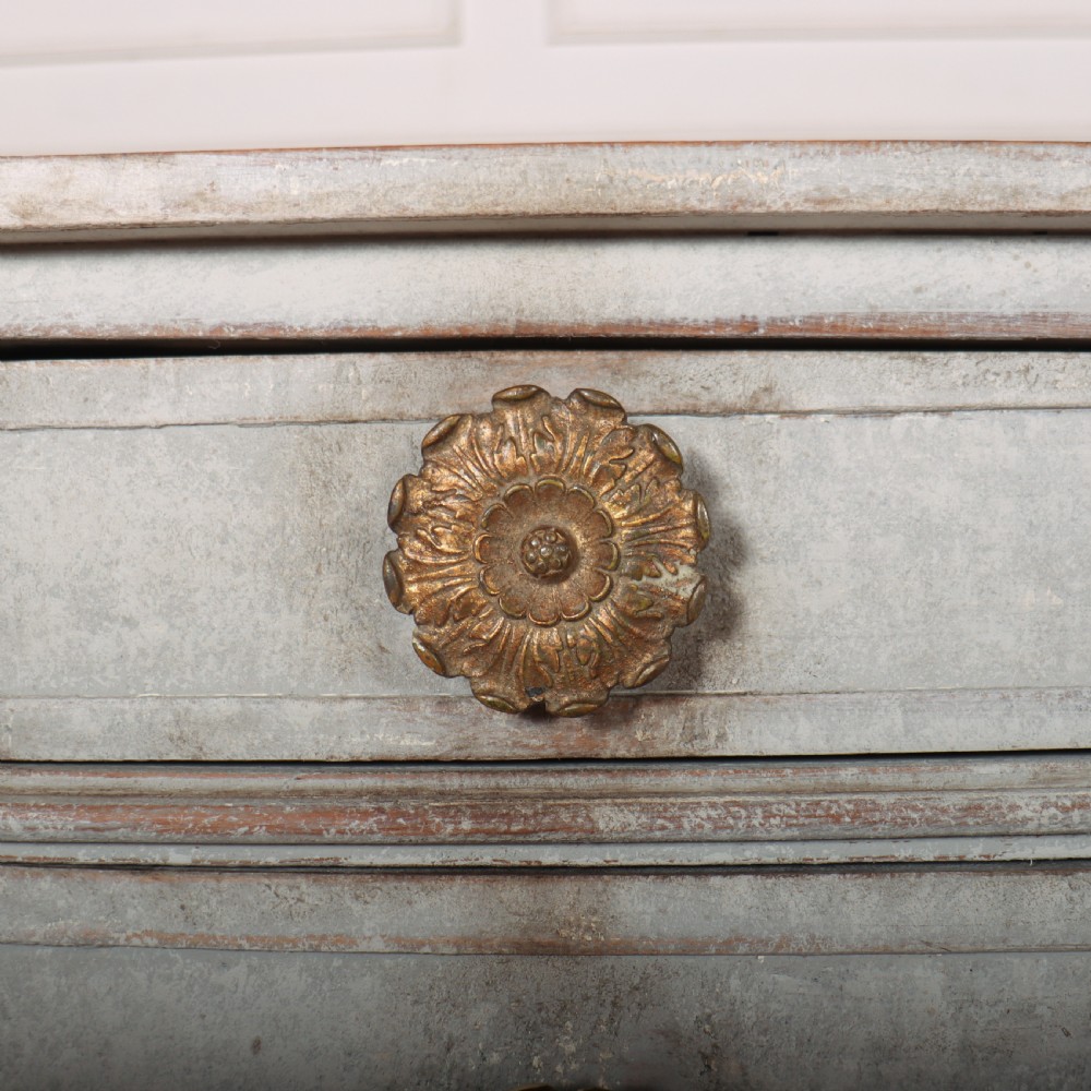 A Louis XVI style pale grey painted oak commode featuring three drawers with gilded rosette handles and fluted legs. View IX