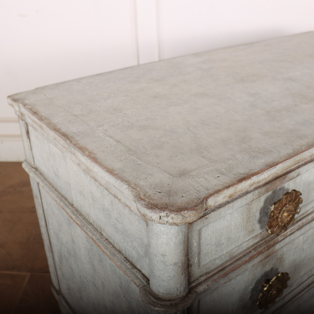 A Louis XVI style pale grey painted oak commode featuring three drawers with gilded rosette handles and fluted legs. View X