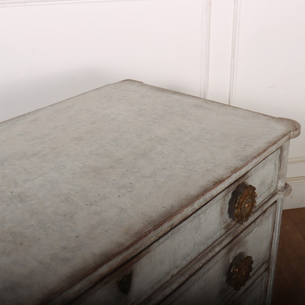A Louis XVI style pale grey painted oak commode featuring three drawers with gilded rosette handles and fluted legs. View XI