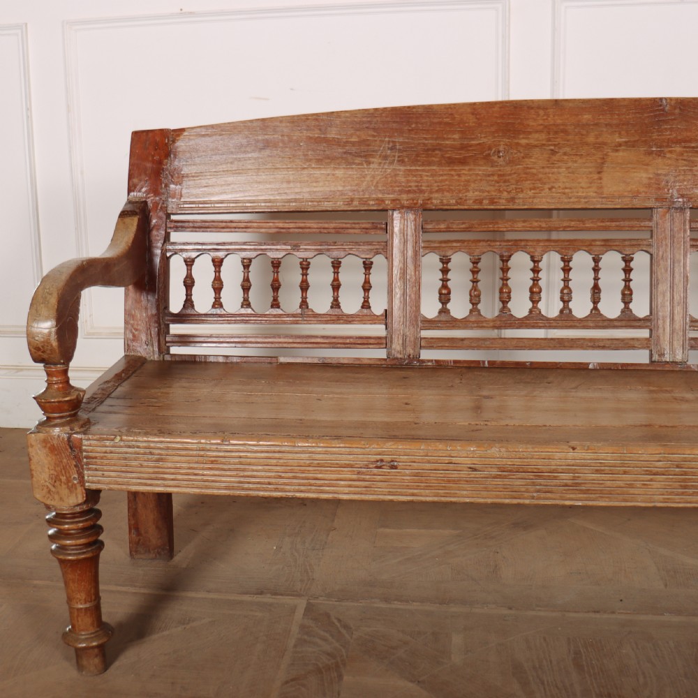 A 19th-century bleached chestnut wooden settle featuring a spindle-detailed backrest, curved armrests, and turned front legs. View III