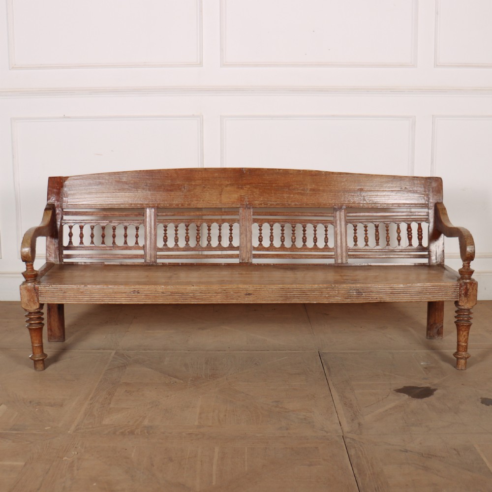 A 19th-century bleached chestnut wooden settle featuring a spindle-detailed backrest, curved armrests, and turned front legs. View IV