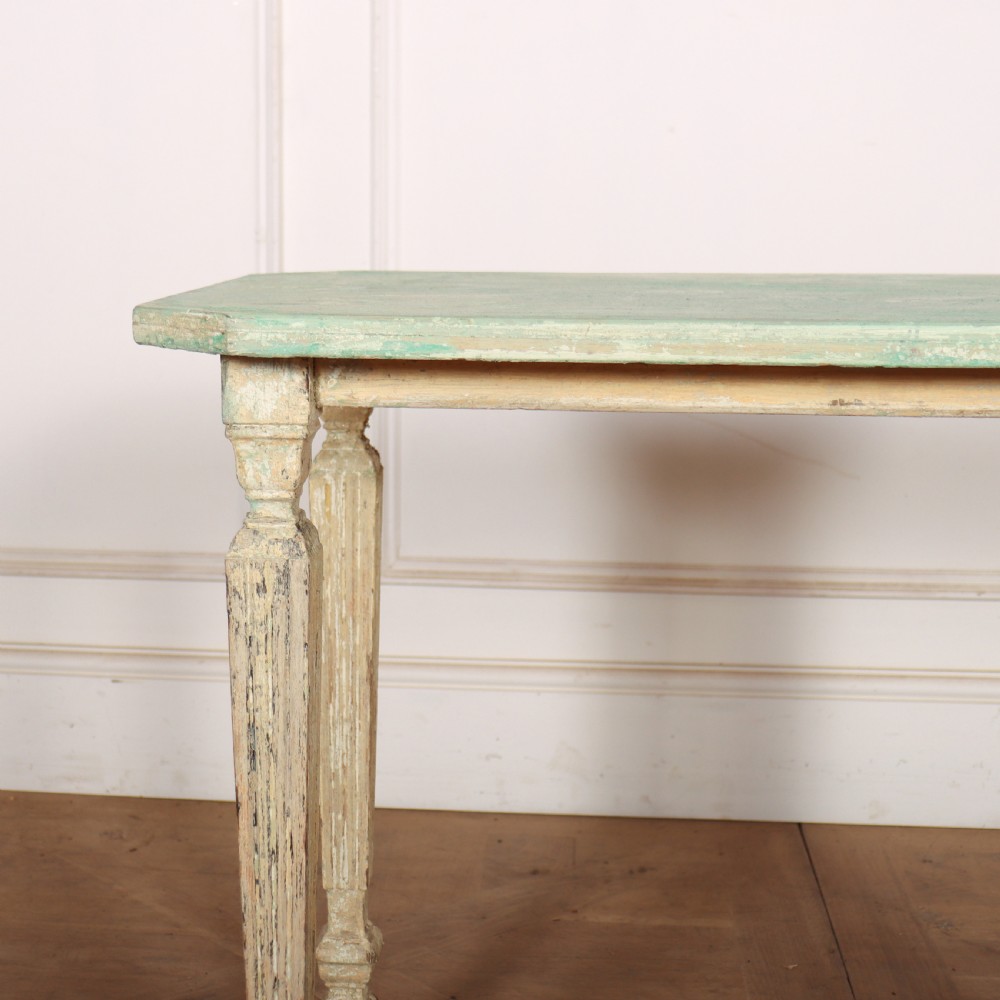A small rectangular French wooden table with a pale green top, clipped corners, and cream distressed painted turned legs with a lower box stretcher. View II
