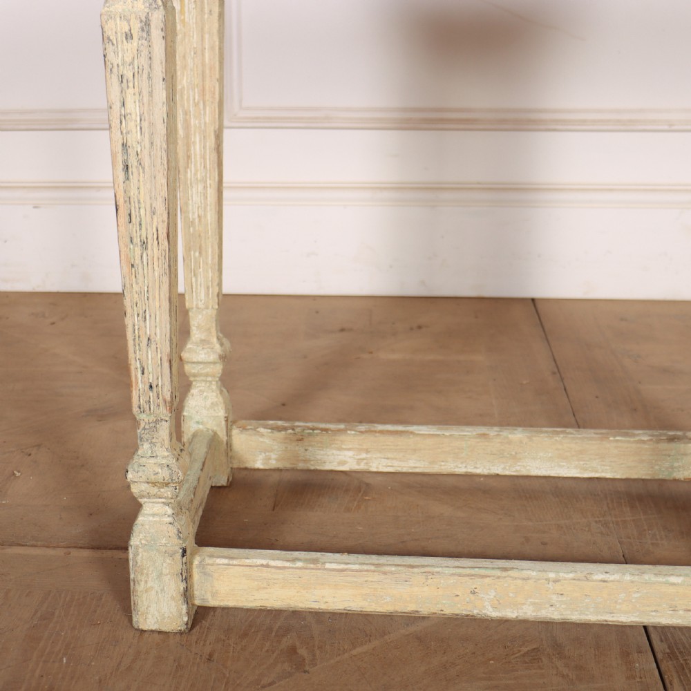 A small rectangular French wooden table with a pale green top, clipped corners, and cream distressed painted turned legs with a lower box stretcher. View III