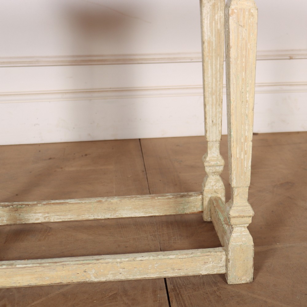 A small rectangular French wooden table with a pale green top, clipped corners, and cream distressed painted turned legs with a lower box stretcher. View IV