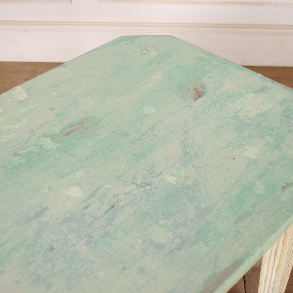 A small rectangular French wooden table with a pale green top, clipped corners, and cream distressed painted turned legs with a lower box stretcher. View VIII