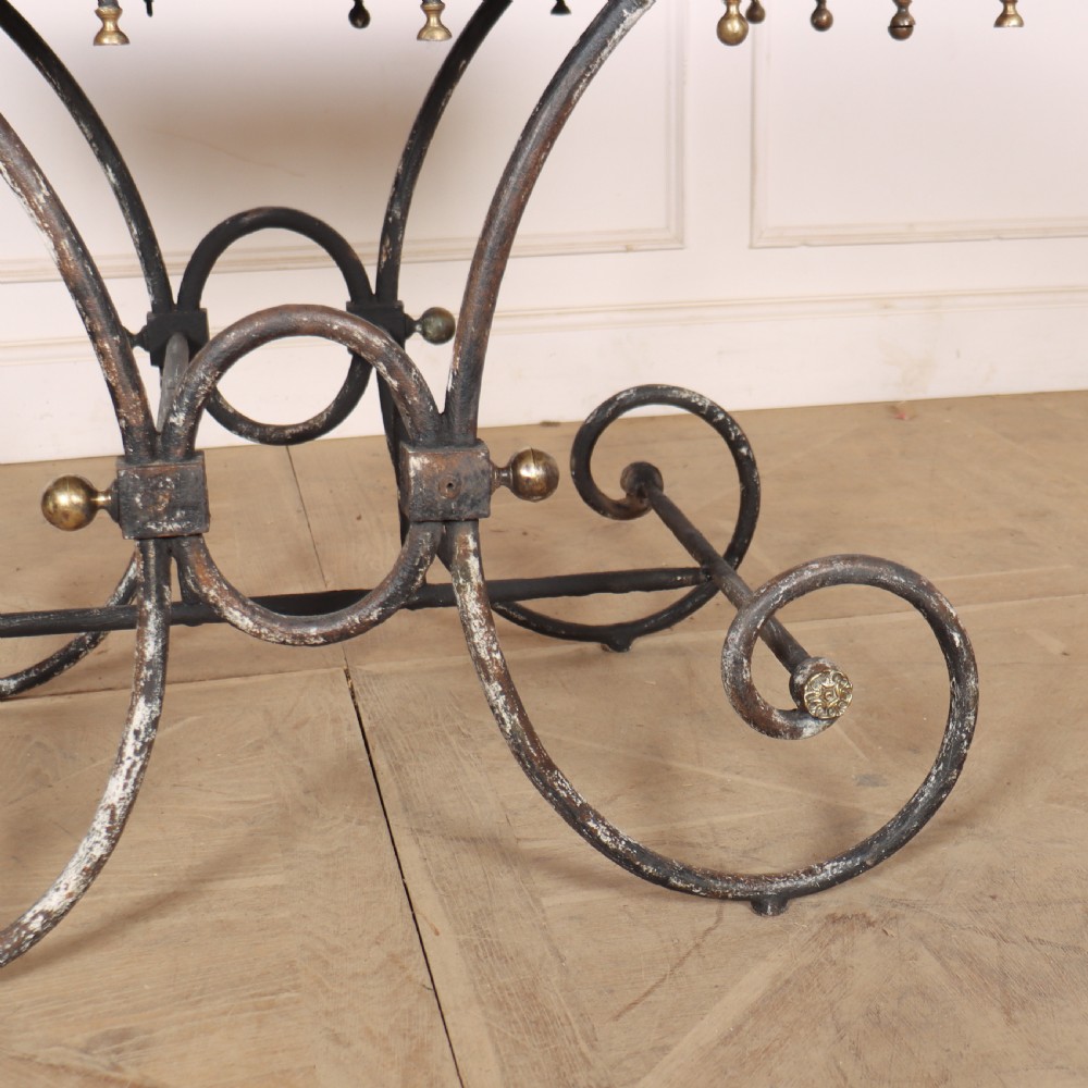 A 19th-century French patisserie table featuring a light marble top mounted on a dark wrought iron scrolled base with brass details. View IV