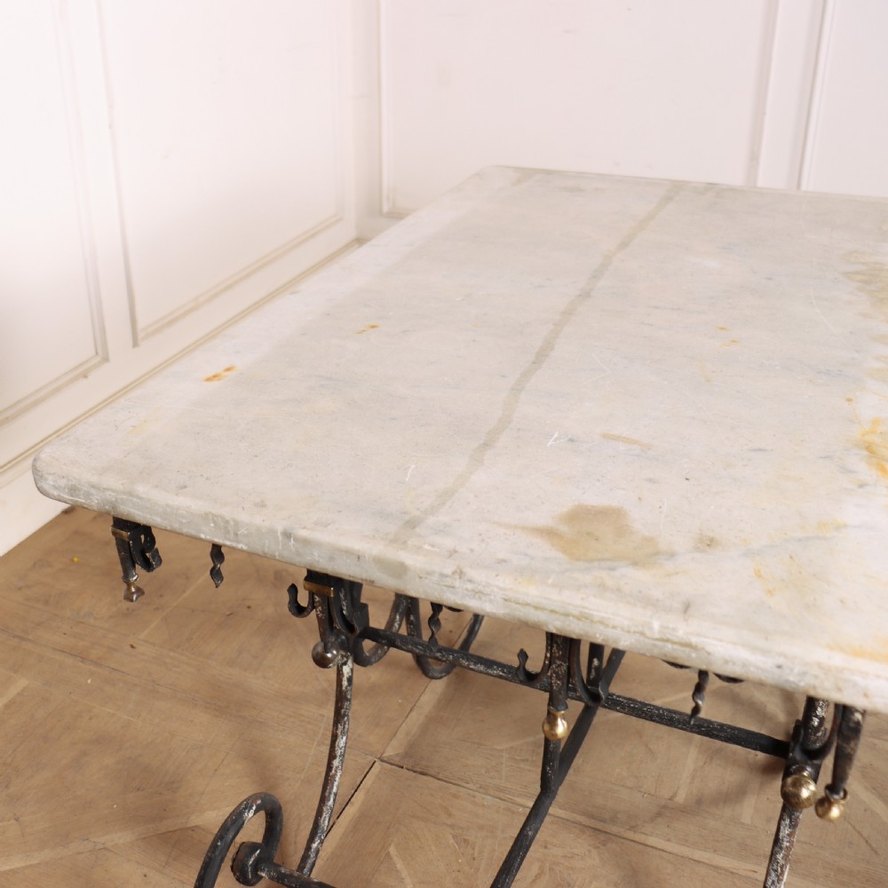 A 19th-century French patisserie table featuring a light marble top mounted on a dark wrought iron scrolled base with brass details. View XI