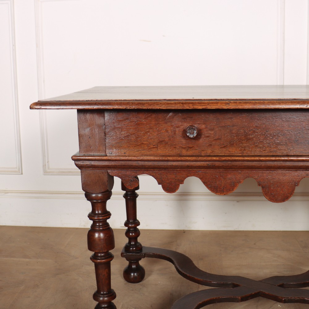 An 18th-century oak lamp table featuring a single drawer with brass knobs, a scalloped apron, turned legs, and an X-frame cross stretcher. View II