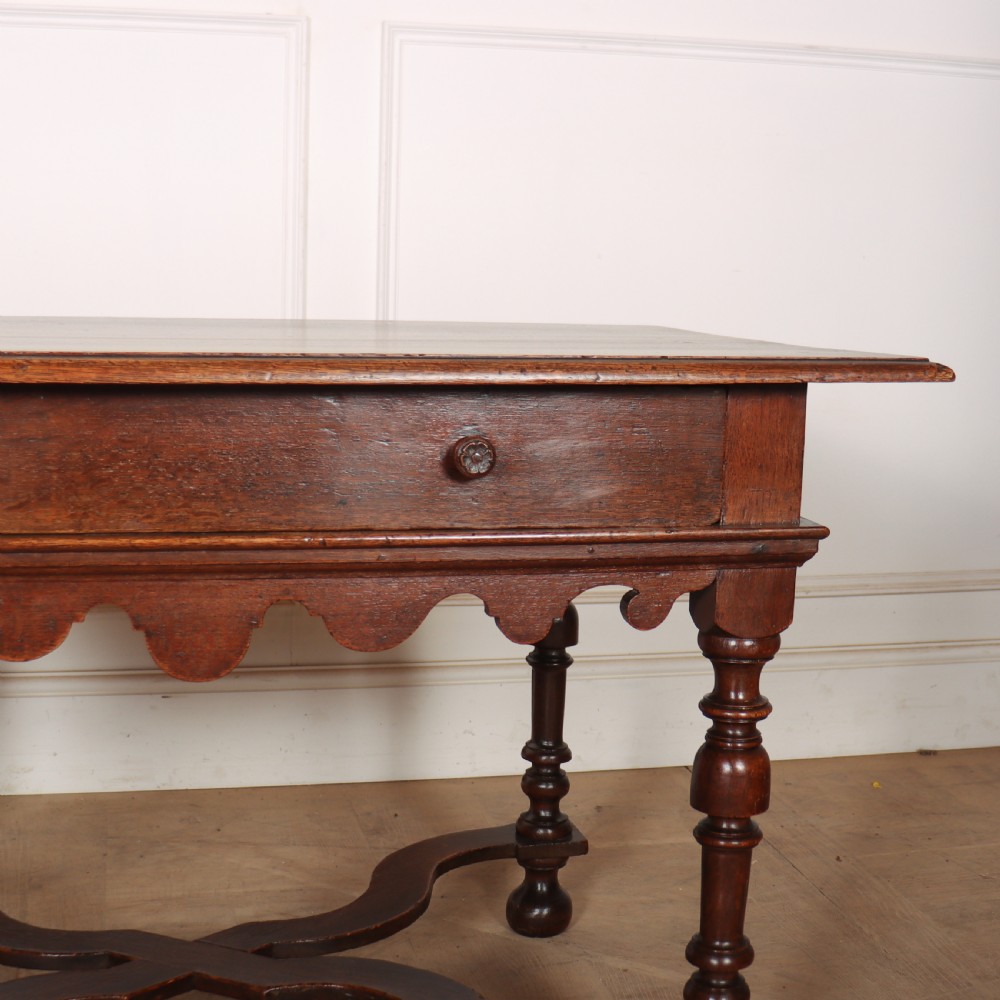 An 18th-century oak lamp table featuring a single drawer with brass knobs, a scalloped apron, turned legs, and an X-frame cross stretcher. View III