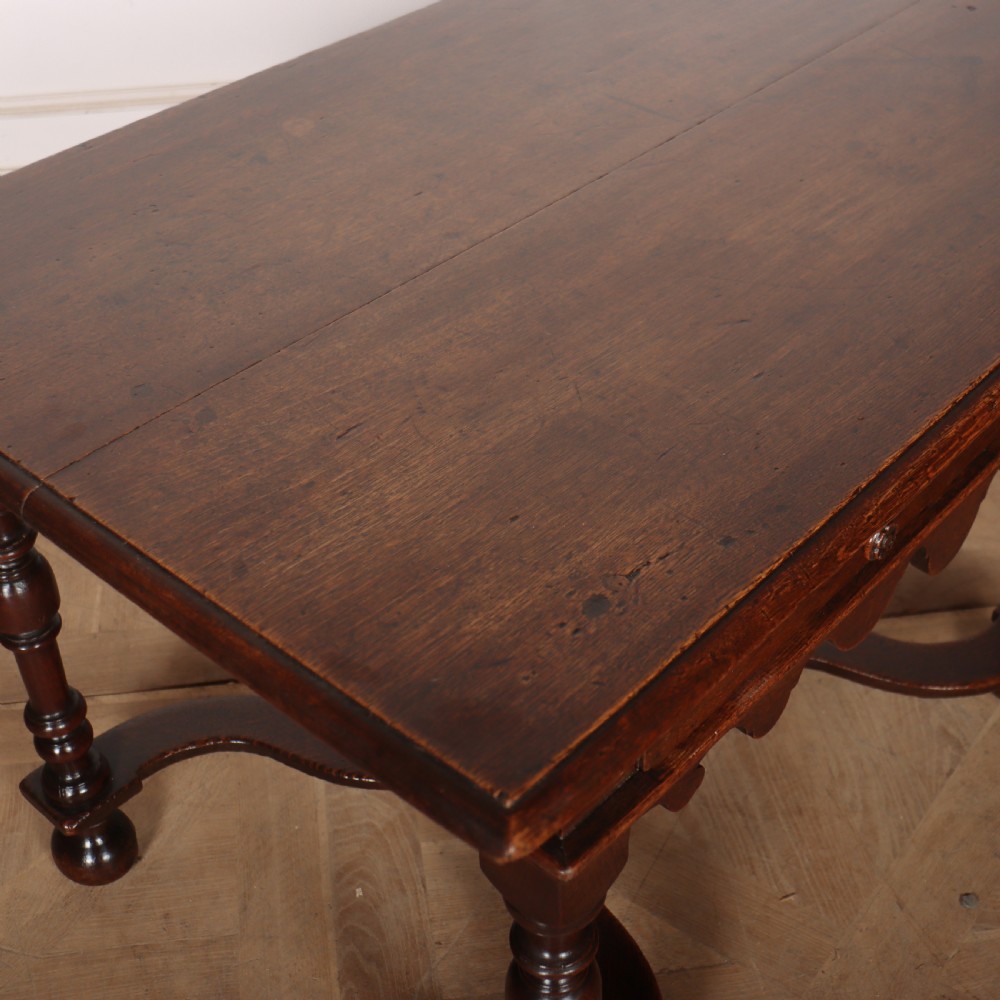 An 18th-century oak lamp table featuring a single drawer with brass knobs, a scalloped apron, turned legs, and an X-frame cross stretcher. View VIII