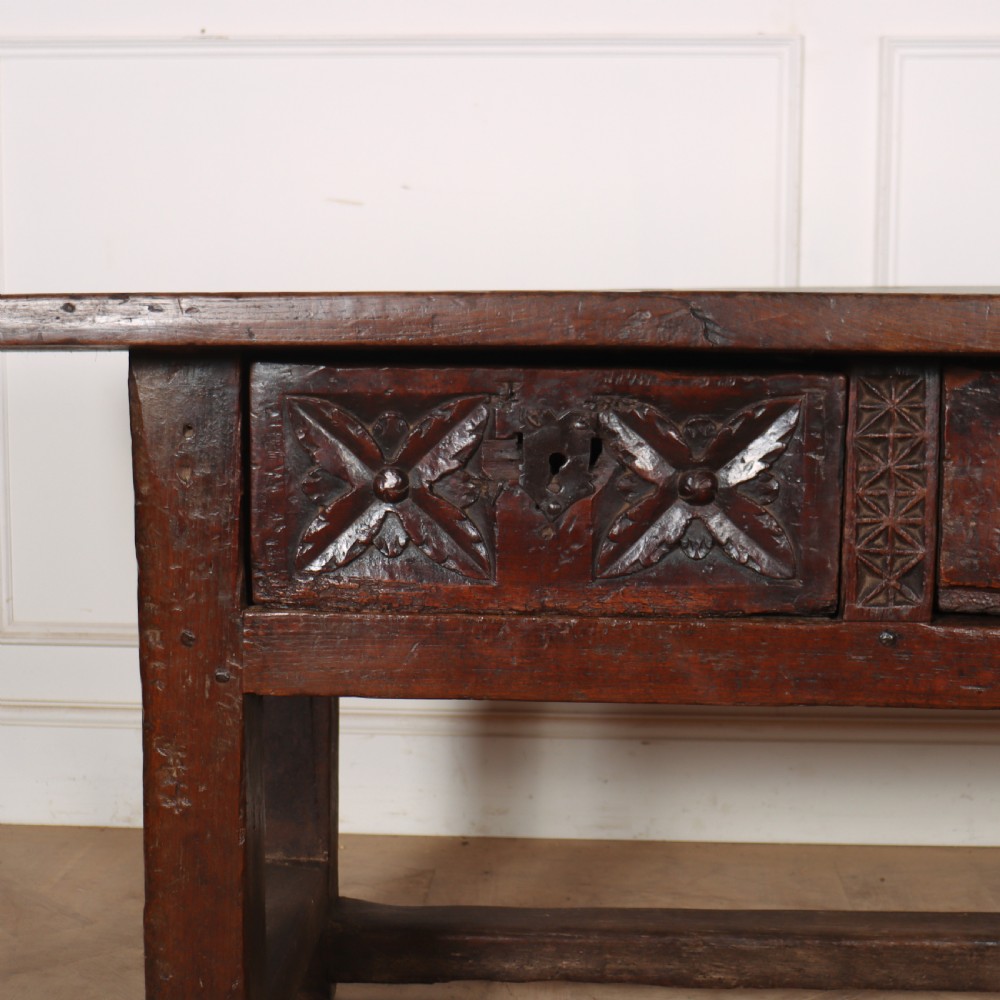 A 17th-century Spanish dark oak console table featuring a thick rectangular top over three geometric carved drawers, supported by sturdy legs with a perimeter stretcher. View II