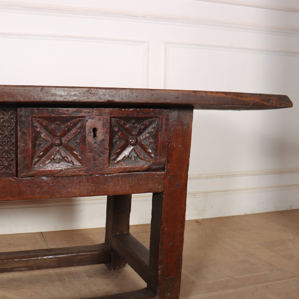 A 17th-century Spanish dark oak console table featuring a thick rectangular top over three geometric carved drawers, supported by sturdy legs with a perimeter stretcher. View IV