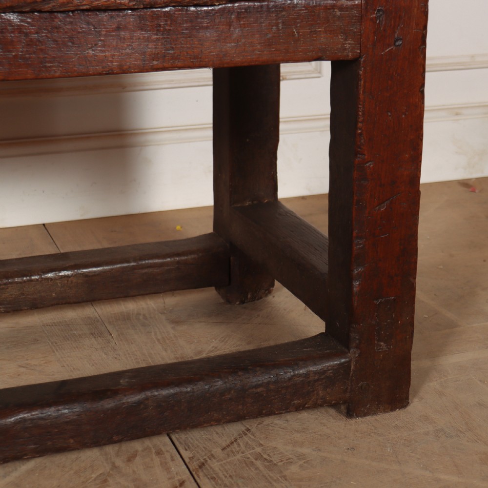 A 17th-century Spanish dark oak console table featuring a thick rectangular top over three geometric carved drawers, supported by sturdy legs with a perimeter stretcher. View V